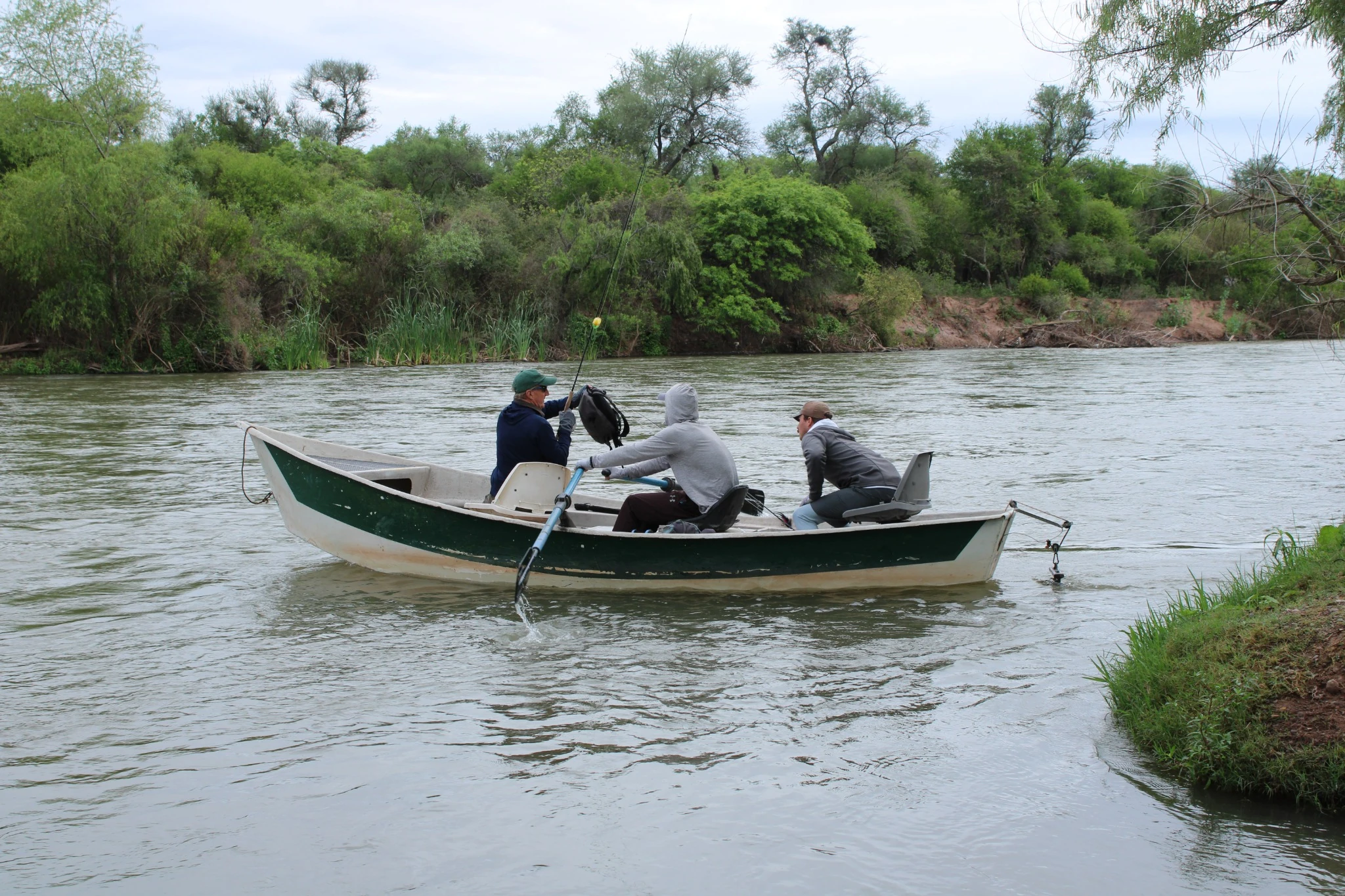 Participantes y cañas a bordo de un bote en el río Juramento.
